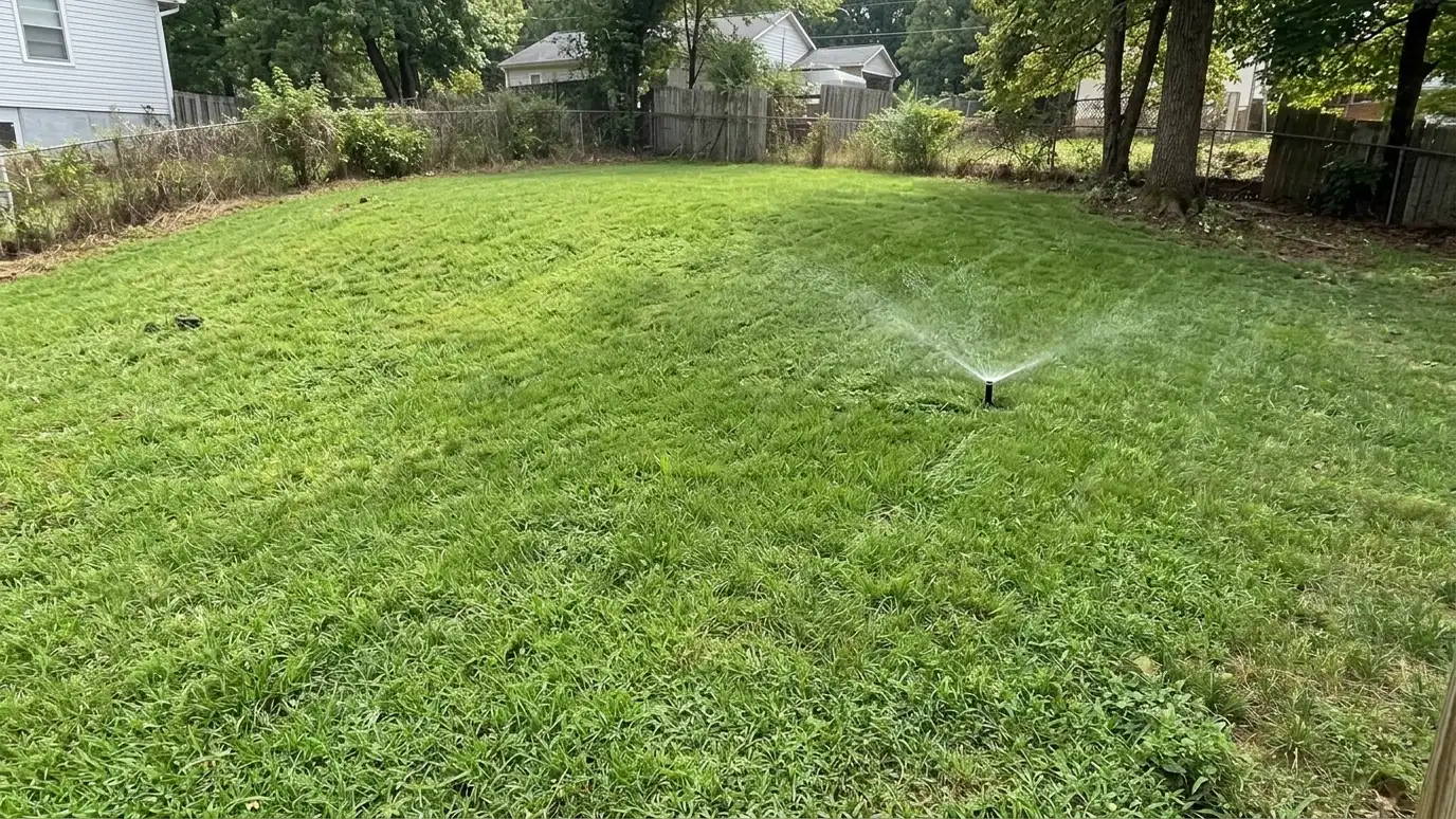 After: Eroded slope turned green | Music City Irrigation After: a sloped yard with thick green grass and a rotor that waters slowly